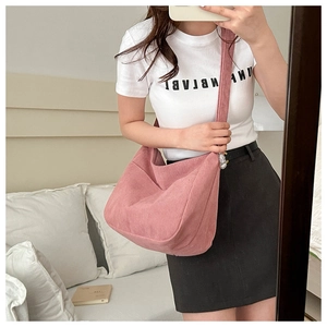 Detail of pink corduroy crossbody bag with soft ribbed texture and large capacity design