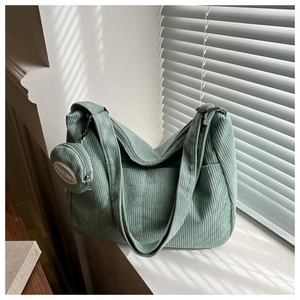 Detailed texture of green corduroy dumpling bag with a matching round coin purse pouch