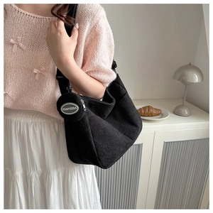 Detail of black corduroy hobo bag with a matching small round coin purse and soft texture