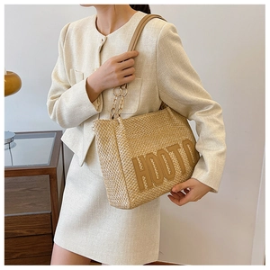 Detail of woven beige tote bag with HOOTO 3D letters and metal chain handle