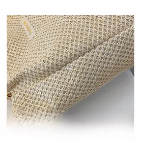 Macro detail of beige woven tote texture with a white leather fashion label and stitching
