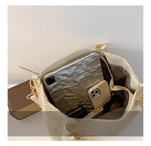 Interior capacity of woven straw tote bag showing tablet, phone, and makeup essentials