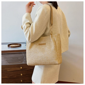 Detail of woven straw tote bag with leather Fashion tag and metal ring shoulder strap