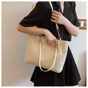 Detail of cream straw tote bag with white leather straps and fashion label detail