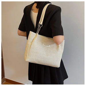 Detail of beige straw tote bag with FASHION label and gold chain shoulder straps