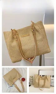 Detailed view of woven khaki tote bag with fashion tag and golden chain strap decoration