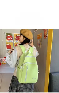 Details eines hellgrünen wasserdichten Nylon-Rucksacks mit mehreren Reißverschlussfächern