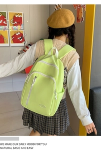 Detailansicht eines hellgrünen, wasserfesten Rucksacks mit Multi-Taschen-Design am Model