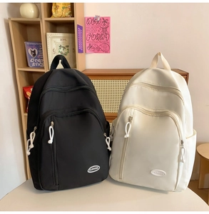 Detailansicht großer Schulrucksäcke aus Nylon in Schwarz und Beige mit Fashion-Patches