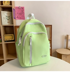 Detail eines minzgrünen Schulrucksacks mit Mehrfachtaschen-Design und Mode-Label