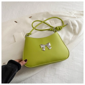 Close-up of avocado green leather underarm bag with silver bow and knot shoulder strap