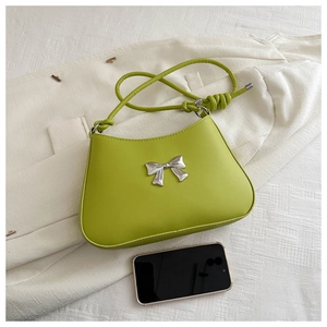 Detail of lime green PU leather shoulder bag with a silver metallic bow and knot strap