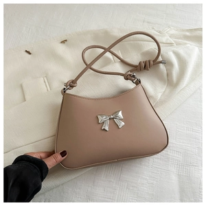 Close-up of khaki shoulder bag with silver metal bow and knotted strap detailing