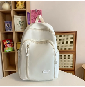 Detail eines weißen wasserfesten Nylon-Rucksacks mit vielen Taschen und Fashion-Logo
