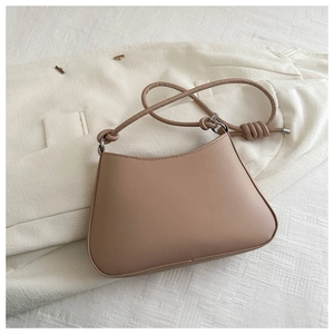 Detailed view of camel leather shoulder bag with stylish knotted strap detail