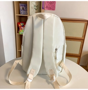 Detail der cremefarbenen Rucksackrückseite mit breiten Gurten und Diebstahlsicherung