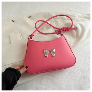 Close-up of pink PU leather handbag featuring a silver metal bow and rope strap detail