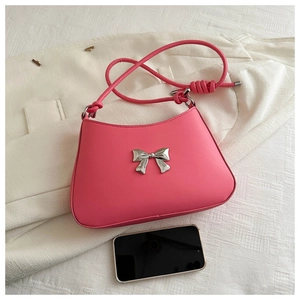 Detailed top view of pink bow shoulder bag with silver hardware and size reference