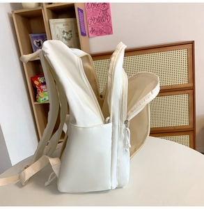 Seitenansicht des weißen minimalistischen Rucksacks mit mehreren Reißverschlüssen