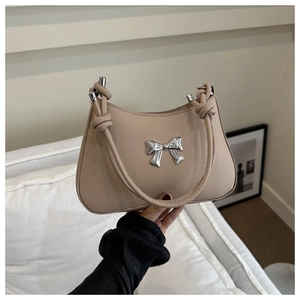 Detail of beige shoulder bag featuring silver bow metal buckle and knotted rope strap