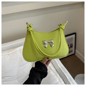 Detail of lime green leather shoulder bag with silver bow accent and knotted strap detail