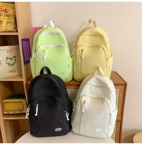 Detailansicht wasserabweisender Nylon-Rucksäcke in Grün, Gelb, Schwarz und Beige Tönen