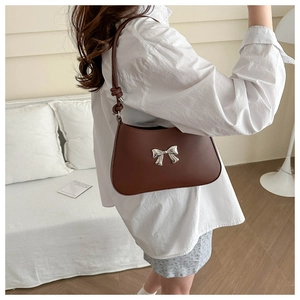 Brown faux leather shoulder bag with silver bow accent and knotted strap detail