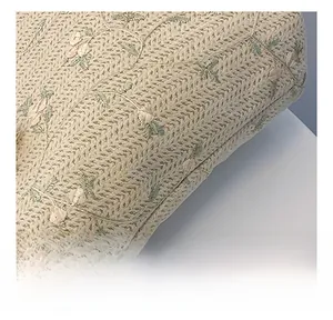 Close-up of beige woven texture with pink flower embroidery on a summer tote bag