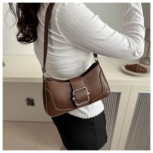 Detail of a brown matte faux leather baguette bag featuring a silver square buckle