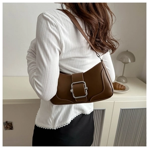 Sac baguette marron en simili cuir avec boucle argentée dans un décor minimaliste