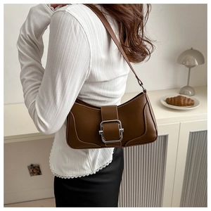 Détail du sac à bandoulière en cuir marron avec une boucle carrée en argent poli
