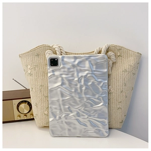 Detail of silver crinkled texture iPad case with precise camera cutouts on woven bag