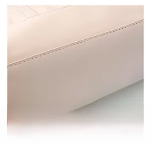 Gros plan d'un sac en cuir beige montrant la texture raffinée et les coutures de précision