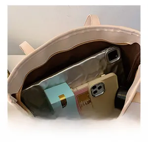 Vue de dessus d'un grand sac cabas crème montrant l'espace intérieur pour les objets