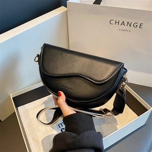 Fashion black saddle shoulder bag with wide strap and gold hardware shown with white gift box