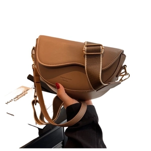 Brown matte leather saddle crossbody bag with adjustable wide nylon strap and slim leather strap