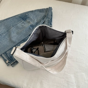 White corduroy crossbody bag with large capacity showing umbrella and glasses inside