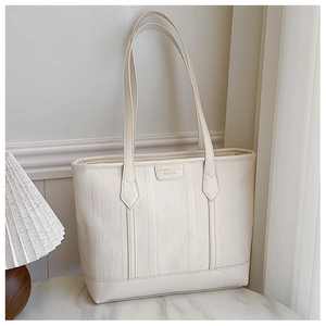 Macro shot of cream large tote bag featuring ripple textured leather and metal logo detail