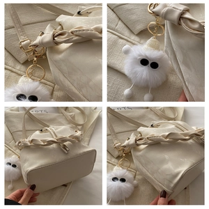 Détails de la poignée tressée et du cuir marbré sur le sac seau crème chic