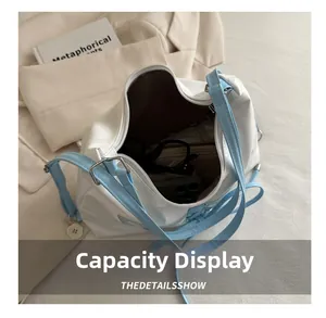 Vue intérieure montrant la grande capacité du sac fourre-tout blanc avec des objets
