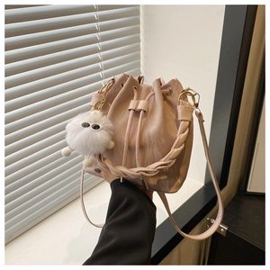 Gros plan du sac seau rose brillant avec fermeture à cordon et breloque en peluche