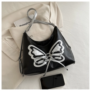 Close-up of the silver butterfly embroidery and metallic shoulder strap on black bag