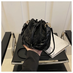 Détail du sac seau noir plissé avec cordon de serrage et poignée tressée élégante
