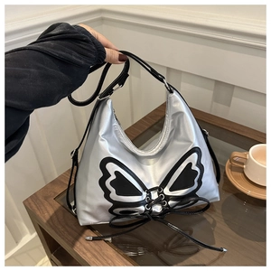 Detail of silver metallic shoulder bag with butterfly wing print and black lace-up design