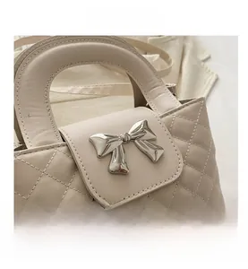 Detailed macro view of quilted cream leather texture and silver bow metal ornament