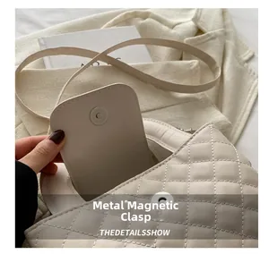 Detail of the high-quality magnetic clasp on beige quilted leather crossbody bag