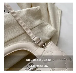 Close-up of adjustable buckle and quilted leather strap on cream crossbody bag