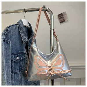 Detail of silver satin shoulder bag with pink butterfly applique on a metal hanger
