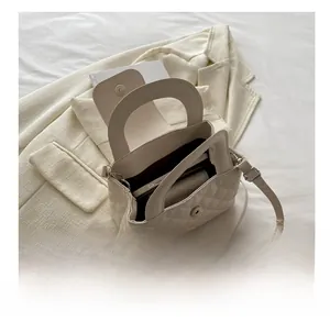 Interior view showing large capacity of the quilted handbag with phone and umbrella
