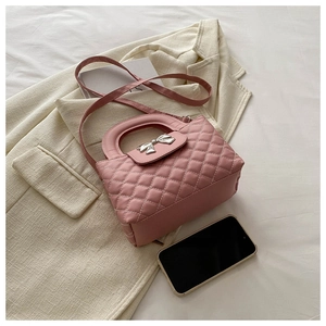 Détail du sac à main matelassé rose avec nœud argenté et poignée intégrée